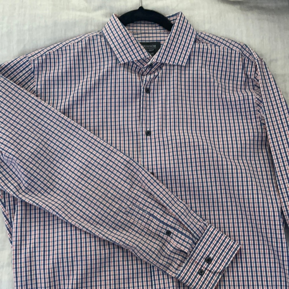 Long sleeved dress shirt. Blue, red, white checkered shirt with black buttons.